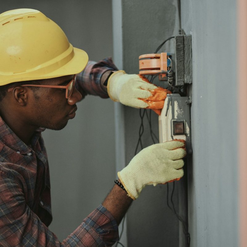 man-in-brown-hat-holding-black-and-gray-power-tool